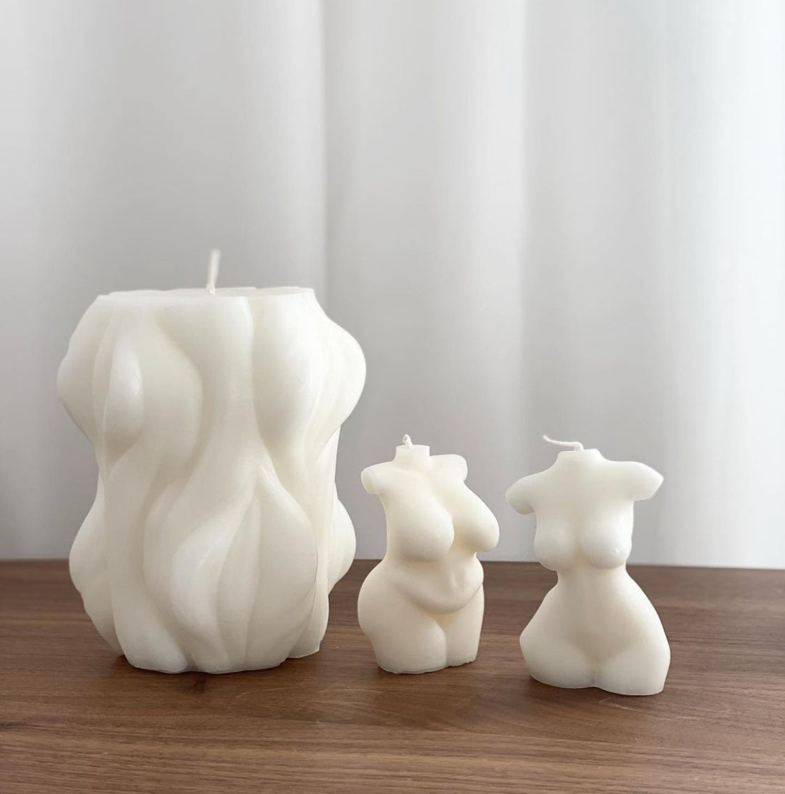 skulpterade vita stearinljus i form av en stock och en kvinnokropp