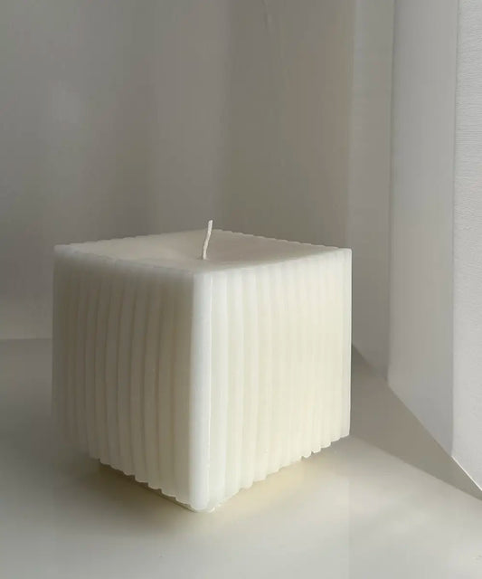 ett stort stearinljus i form av en kub med sidor som är räfflade